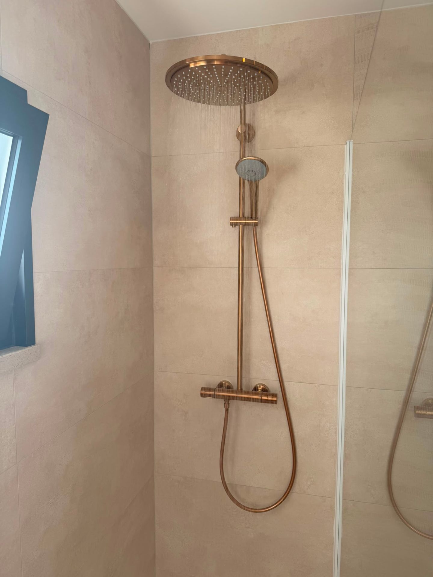 Premium badkamer door Rovari — bronzen regendouche in werking in een strakke walk-in